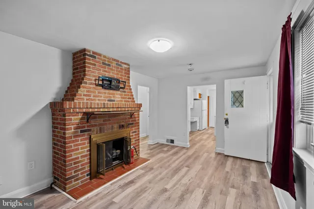 a view of a livingroom with wooden floor and a fireplace