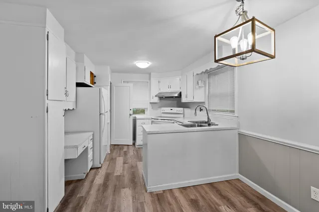 a kitchen with cabinets and wooden floor