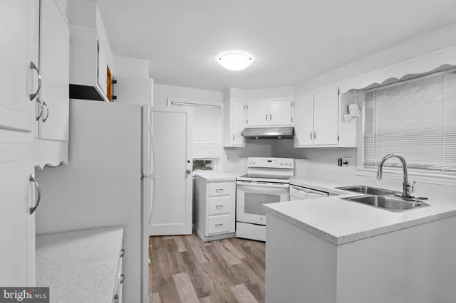 a kitchen with cabinets appliances a sink and a counter top space
