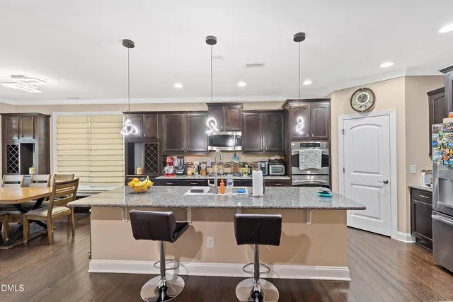 a kitchen with stainless steel appliances granite countertop a stove a sink and a refrigerator