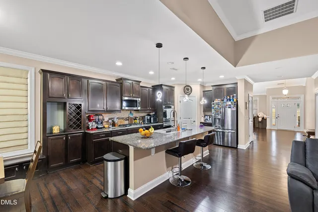 a kitchen with stainless steel appliances granite countertop a refrigerator stove and sink