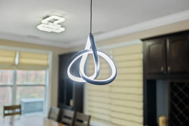 a bedroom with a bed next to a window with a chandelier