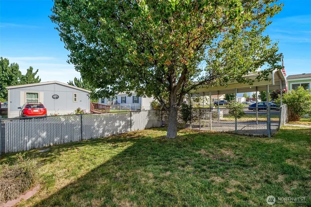 a view of backyard with table and chairs and wooden fence