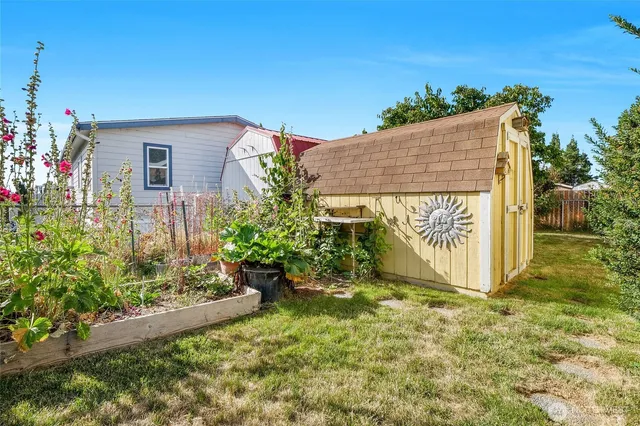 a view of a house with a yard and potted plants