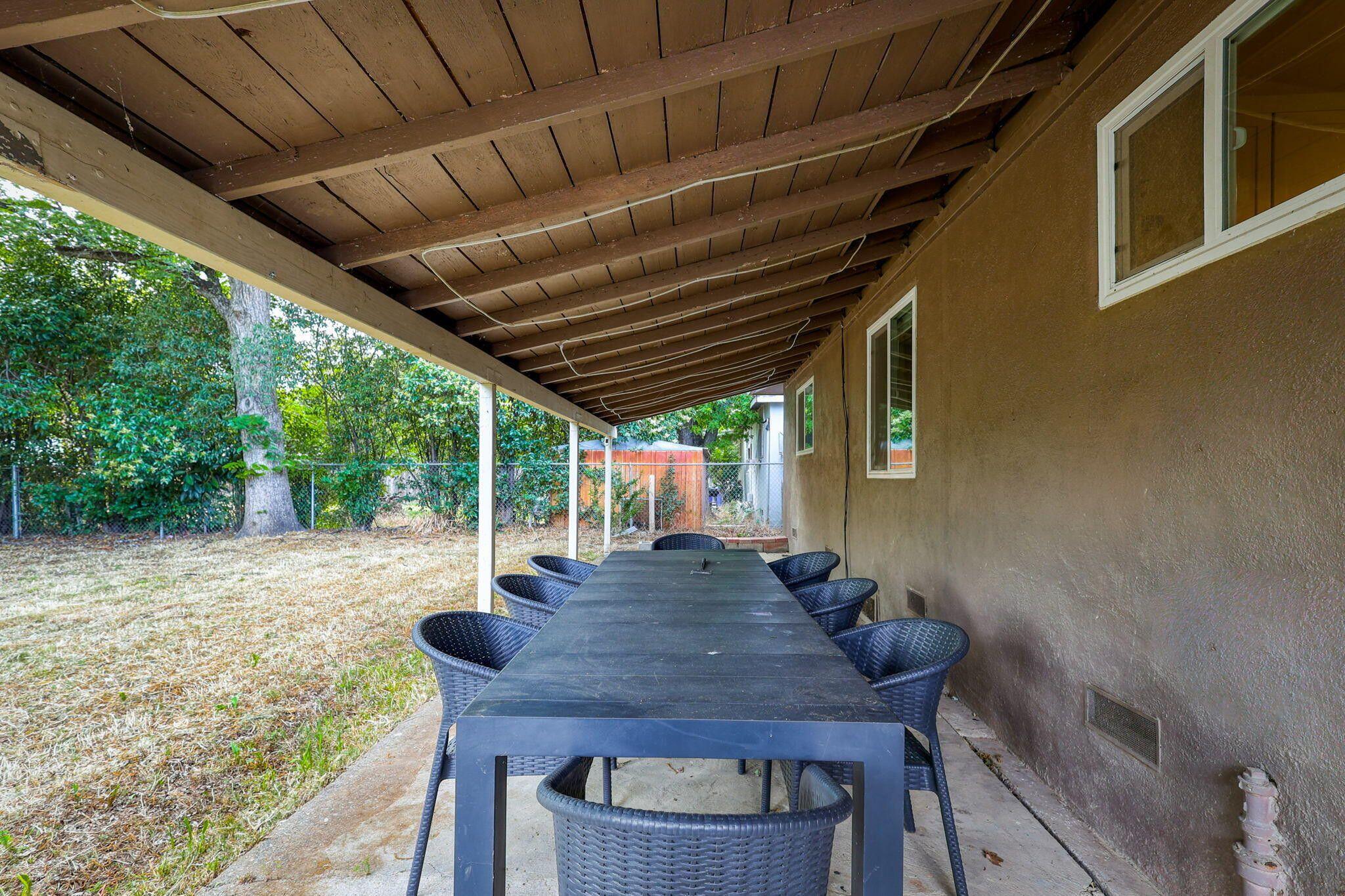 1005 Gold Street Redding, CA 96001 - Photo 22 of 26 a view of a patio with table and chairs with wooden floor and fence