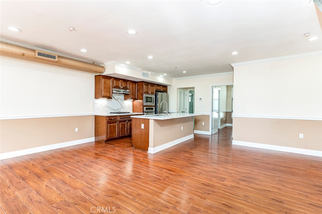596 South Brea Boulevard Brea, CA 92821 - Photo 7 of 33 a large kitchen with stainless steel appliances kitchen island a large counter top and a wooden floors