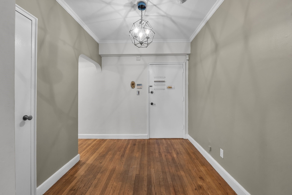 56 Elm Street, Unit 1 Worcester, MA 01609 - Photo 3 of 20 a view of a hallway with wooden floor and chandelier