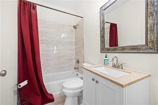 a bathroom with a sink a toilet a mirror and shower