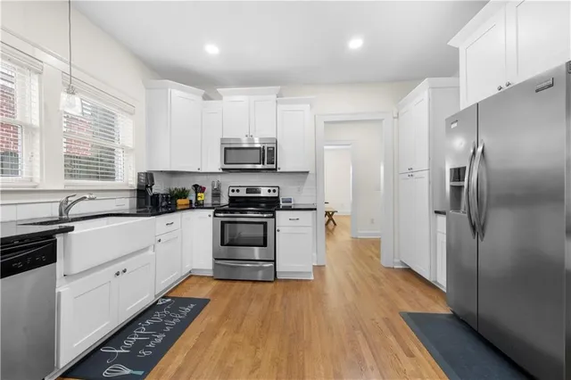 a kitchen with stainless steel appliances a refrigerator sink and wooden floor