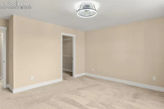 an empty room with a hallway and a chandelier