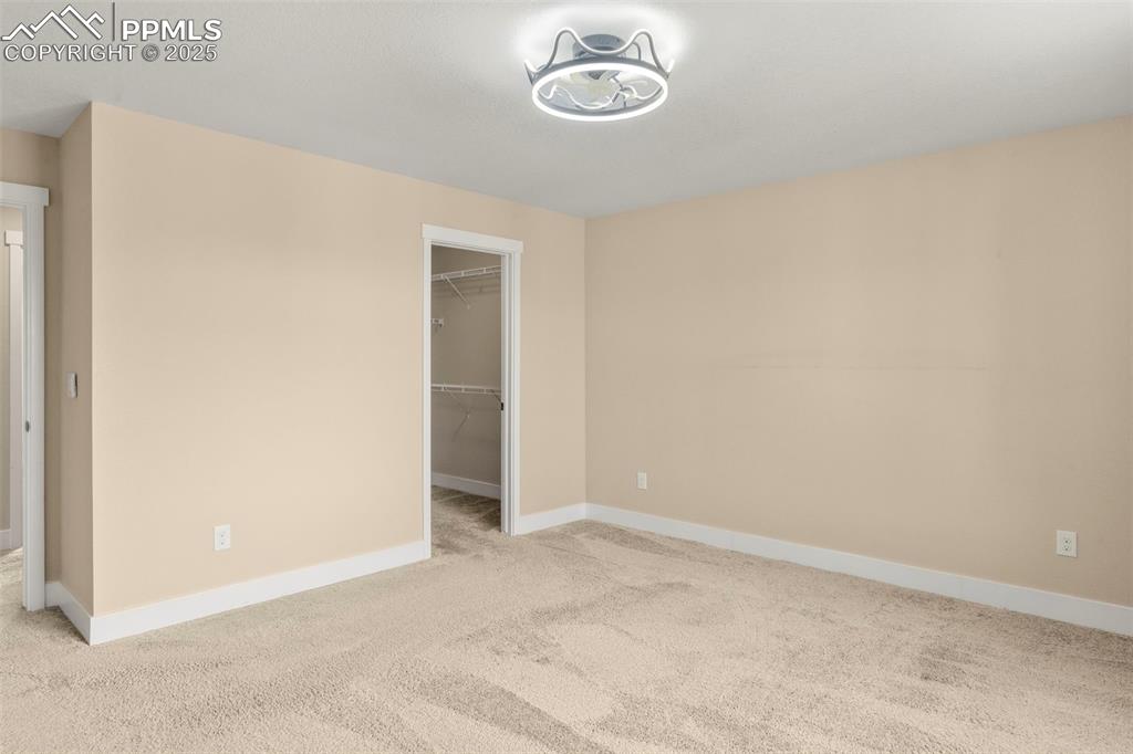 1367 Plentiful Drive Colorado Springs, CO 80921 - Photo 17 of 28 an empty room with a hallway and a chandelier