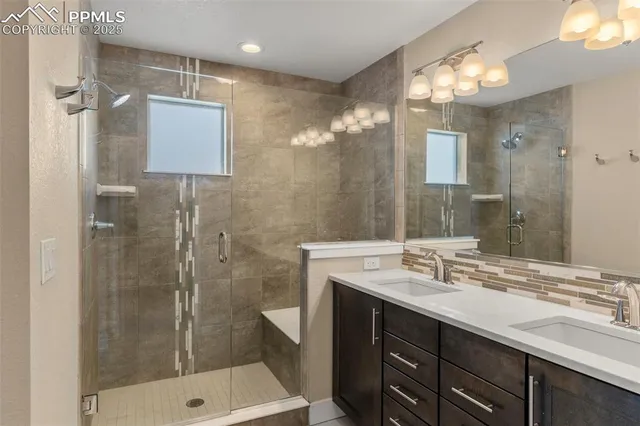 a bathroom with a shower sink vanity and mirror