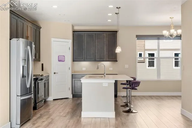 a kitchen with stainless steel appliances a refrigerator and a stove top oven