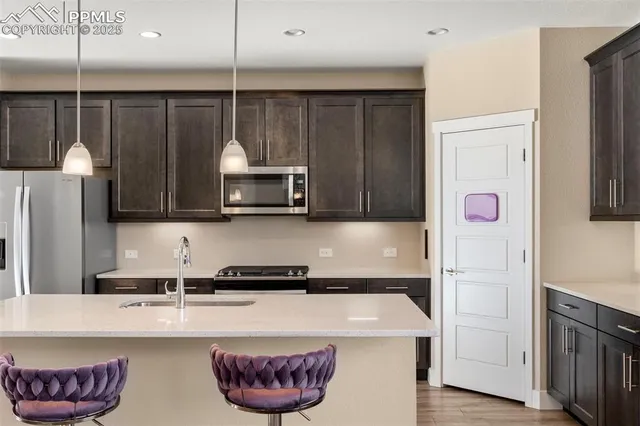 a kitchen with stainless steel appliances granite countertop a sink a stove and a refrigerator