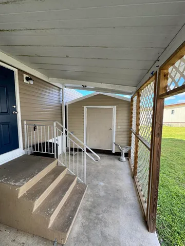 a view of a porch with furniture and a yard