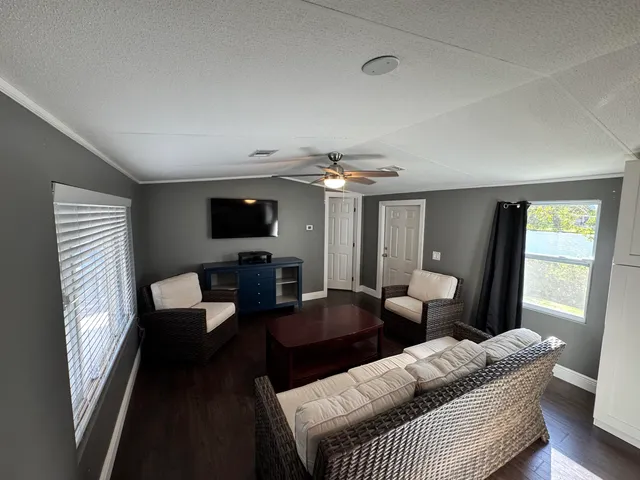 a living room with furniture a flat screen tv and a window