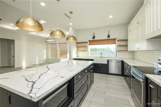 a kitchen with stainless steel appliances granite countertop a sink counter space cabinets and a stove