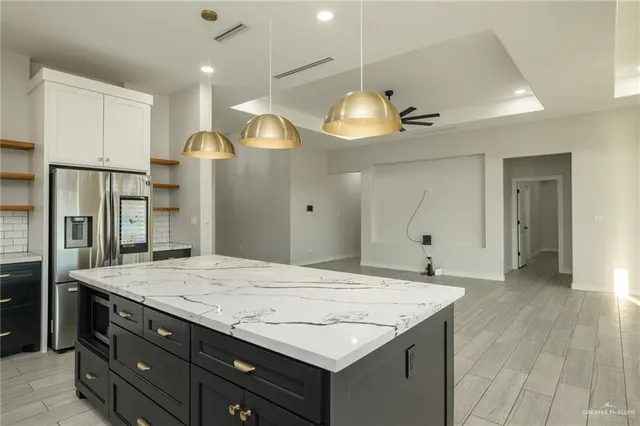 a view of a kitchen island a chandelier and wooden floor