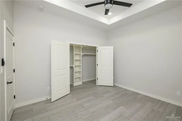 an empty room with closet and a ceiling fan