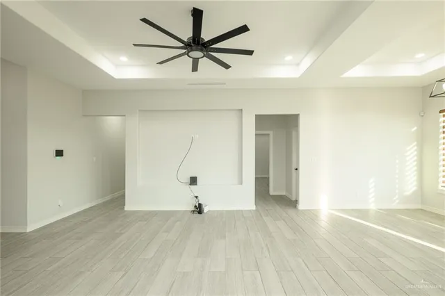 a view of room with a ceiling fan and wooden floor