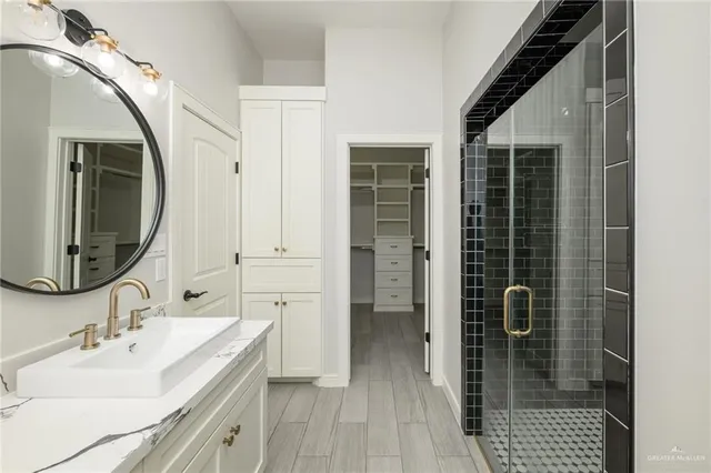 a en suite bathroom with a sink a mirror and shower