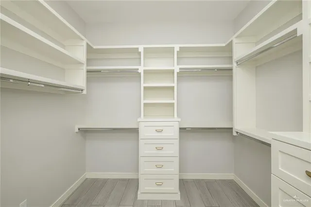 a view of walk in closet with empty racks