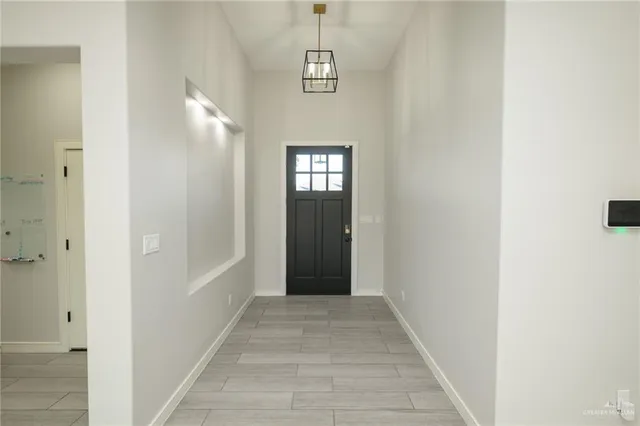 a view of a hallway with wooden floor and a bathroom