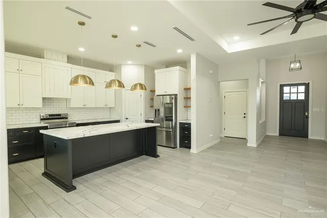 a large kitchen with stainless steel appliances granite countertop a stove and a sink