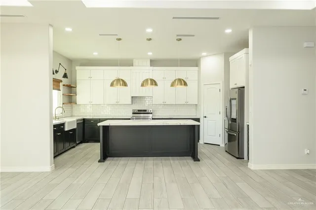 a large white kitchen with a sink a refrigerator and a stove