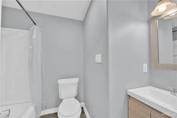 a white toilet sitting next to a white sink and vanity