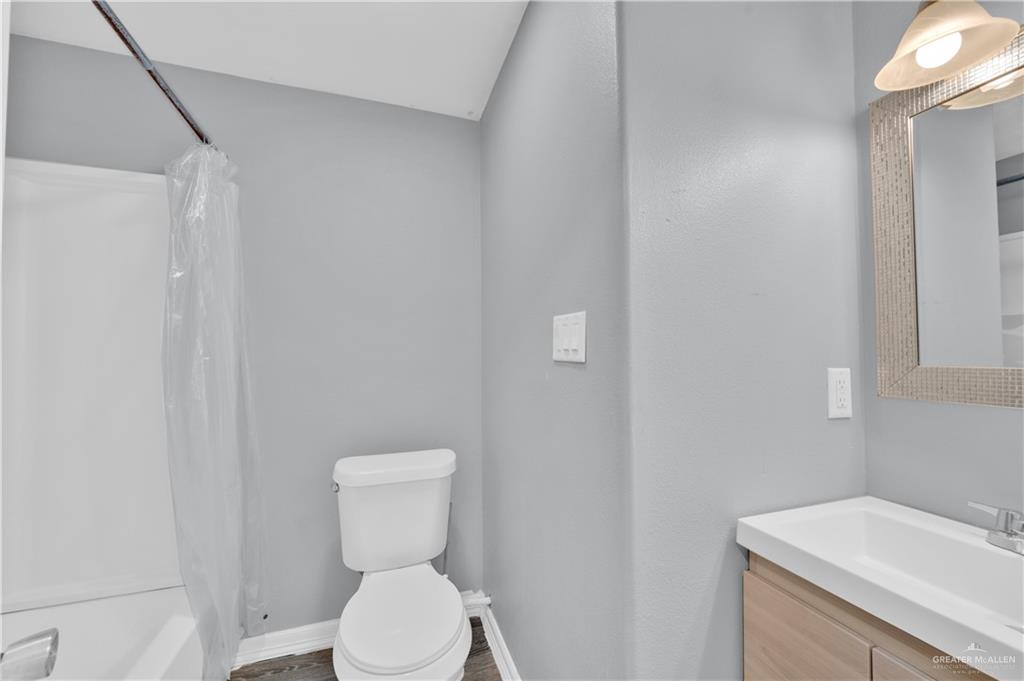 405 East Guerra Street Rio Grande City, TX 78582 - Photo 24 of 33 a white toilet sitting next to a white sink and vanity