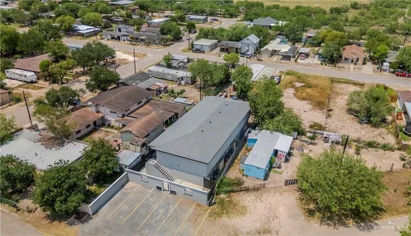 an aerial view of a residential houses with outdoor space and parking
