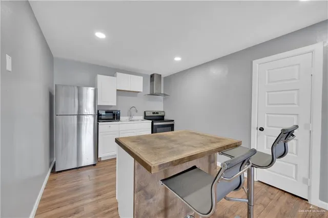 a kitchen with a refrigerator a microwave and cabinets