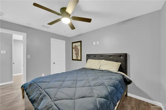 a bedroom with a large bed and a ceiling fan