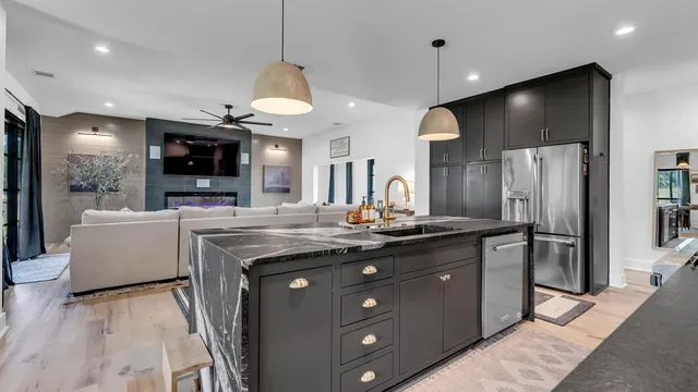 a kitchen with stainless steel appliances granite countertop a sink a stove and a refrigerator