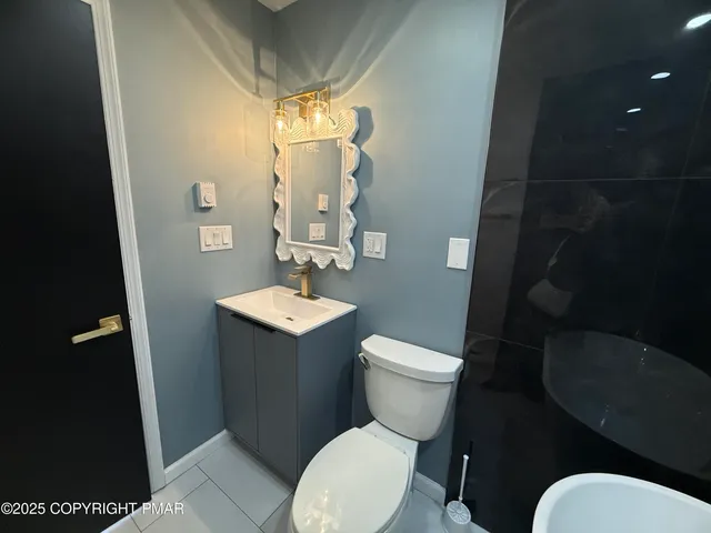 a white toilet sitting next to a bathroom sink and a mirror