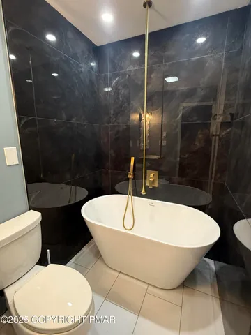 a bathroom with a bathtub and toilet