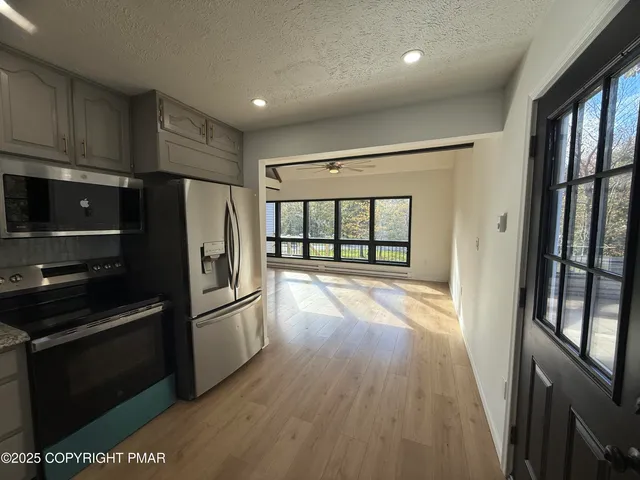 a kitchen with granite countertop a refrigerator and a stove top oven
