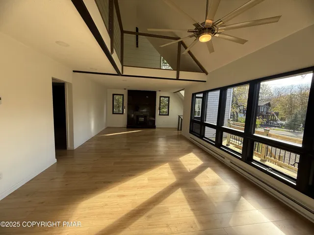 a view of empty room with wooden floor and windows