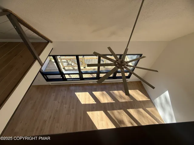 a view of empty room with wooden floor and fireplace