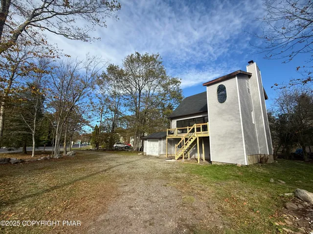 a view of backyard with wooden fence and a large tree