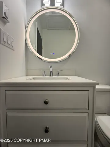a bathroom with a toilet sink and mirror