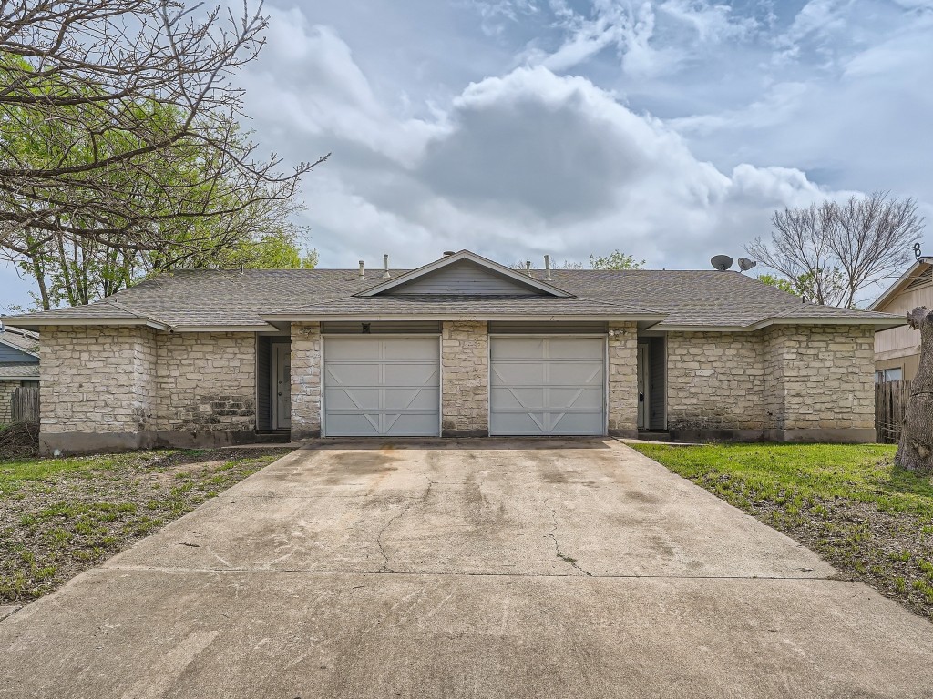 a front view of a house with a garden and garage