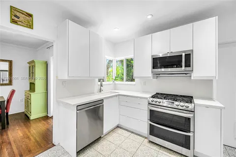 a kitchen with cabinets stainless steel appliances and wooden floor