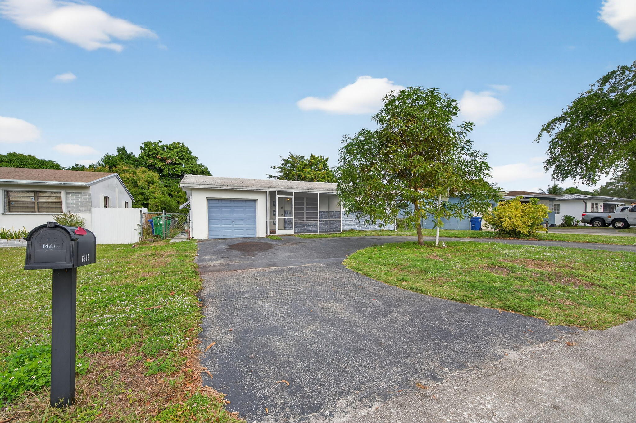 a view of a house with a small yard and a large tree