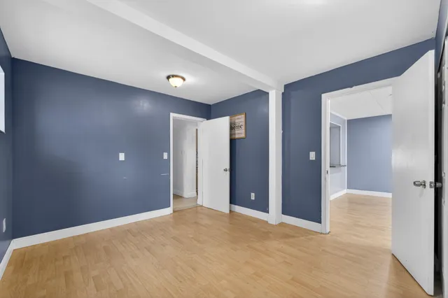 a view of an empty room with window and closet area