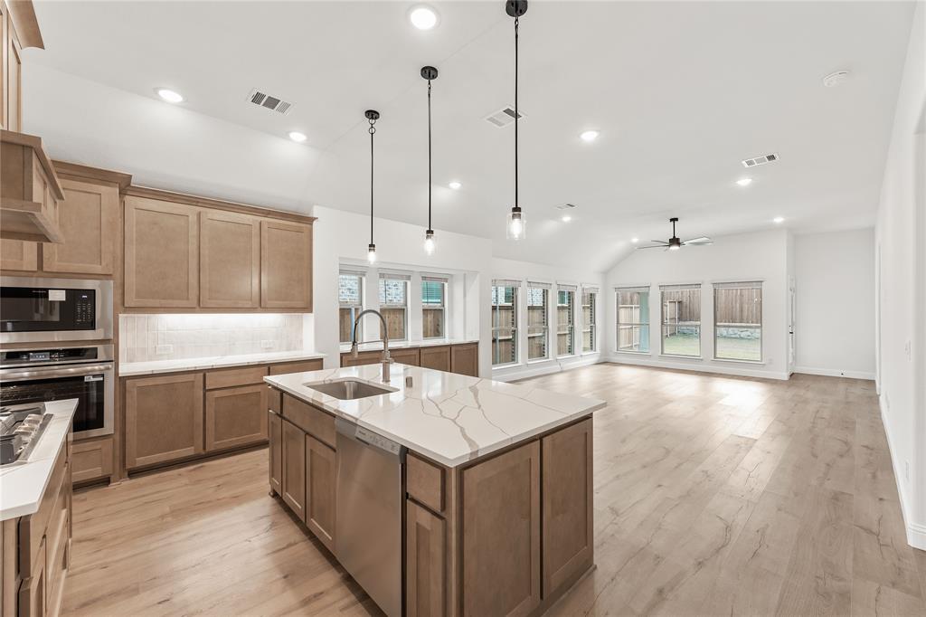 14509 Lovelace Street Pilot Point, TX 76258 - Photo 11 of 35 a kitchen with stainless steel appliances granite countertop a sink a oven and a wooden floors