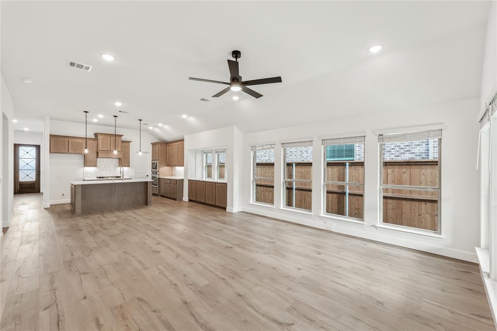 14509 Lovelace Street Pilot Point, TX 76258 - Photo 16 of 35 a view of a kitchen with kitchen island a sink wooden floor and a large window