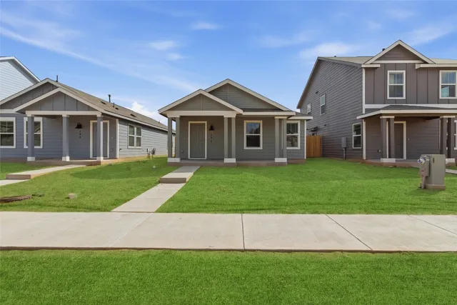 a front view of a house with a yard and trees
