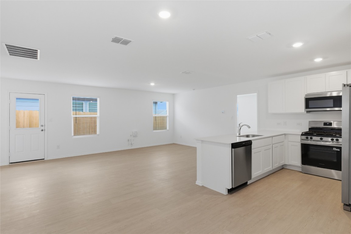 596 Sormonne Loop Kyle, TX 78640 - Photo 25 of 25 a kitchen with granite countertop white cabinets and stainless steel appliances